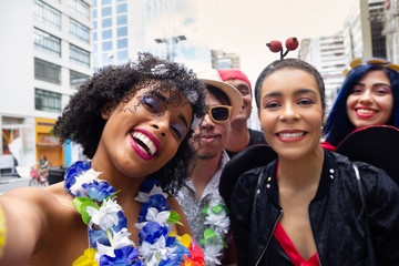 Friends at street party take a self portrait. Brazilian Carnival. People in costume celebrating the...