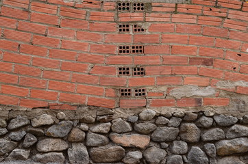 muro de ladrillos con base de piedras