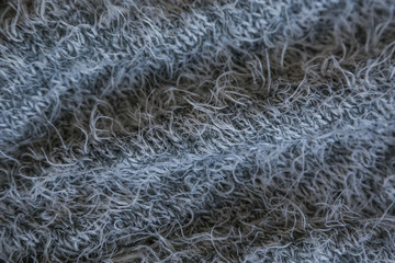 Gray knitted background. Close up gray fabric texture background. wrinkled and shadows, selective focus top view