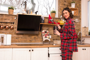 winter morning young woman in pajama preparing coffee in modern house kitchen, happy and smiling