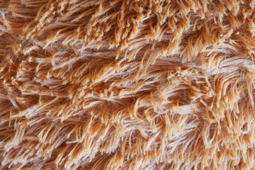 Fluffy and fleecy warm fabric. Light brown background or backdrop. Daylight
