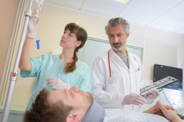 doctor and nurse talking to patient on bed