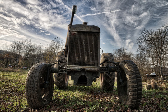 Old rusty tractor in a field on a sunny day