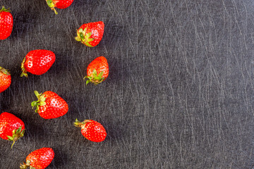 Fresh strawberries lying on a black background - 309851120