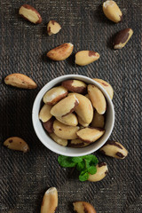 Fototapeta na wymiar Brazilian nuts in a bowl on a wooden table. Kitchen background.
