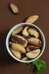 Brazilian nuts in a bowl on a wooden table. Kitchen background.
