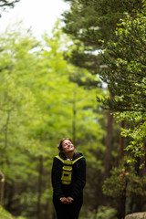 A tourist hike girl, smiling and feeling happy, during a walk in the forest of Pyrenees mountains of Andorra, near Encamp