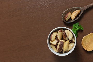 Brazilian nuts in a bowl on a wooden table. Kitchen background.