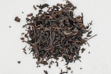 Handful of black tea on a white background close-up