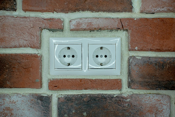 white double socket is built into the brick wall
