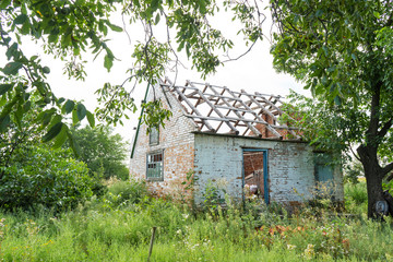 Fototapeta na wymiar abandoned building without a roof in an overgrown field