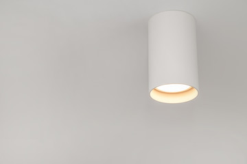 White ceiling spot lamp tube-shaped.