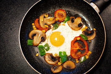 Freshly fried eggs with vegetables in a pan