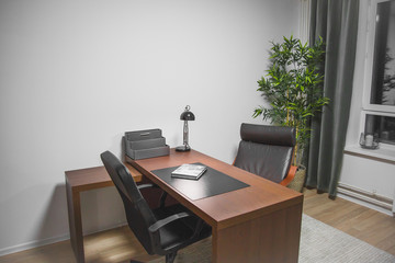 minimalistic home office interior cabinet in brown tones: table, leather chairs, lamp 