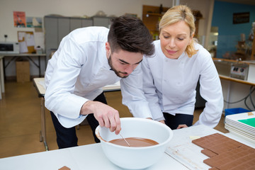 chocolatier apprentice mixing melted chocolate