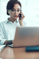 Young female worker is using mobile phone