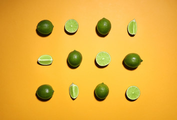 Flat lay composition with fresh juicy limes on yellow background