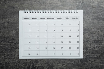 Paper calendar on grey stone background, top view