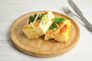 Tasty broccoli casserole served on white wooden table