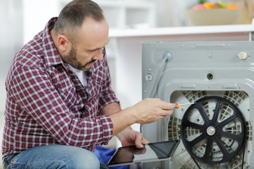 plumber fixing domestic washing machine