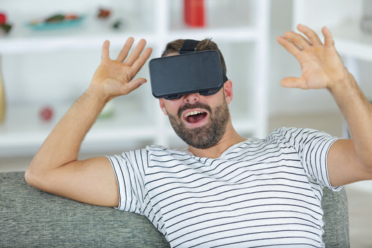 happy smiling man with vr headset try to touck reality