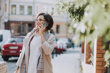 Happy young woman is walking in the city