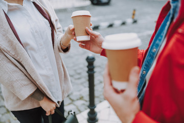 Man giving hot drink for woman in the city