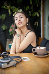 Asian smile girl in a cafe. Beautiful Balinese women with a cup of coffee