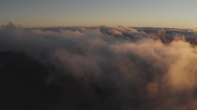 Flight through the clouds over mountains. Aerial view of clouds. Beautiful nature landscape. Birds point of view.
