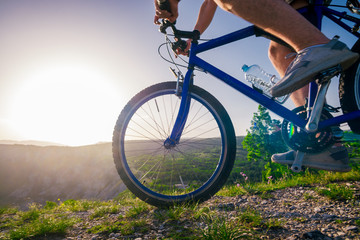 Fototapeta premium Close up photo from a mountain biker riding his bike ( bicycle) on rough rocky terrain on top of a mountain, wearing no safety equipment. Adrenalin junkie.