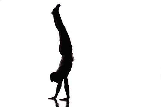 Teenager dancing breakdance in action while doing handstand