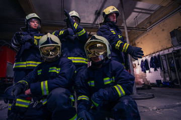 Obraz premium Portrait of group firefighters in front of firetruck inside the fire station