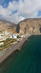 Aerial drone panoramic photo of famous black sand volcanic beach of Perissa in island of Santorini, Cyclades, Greece
