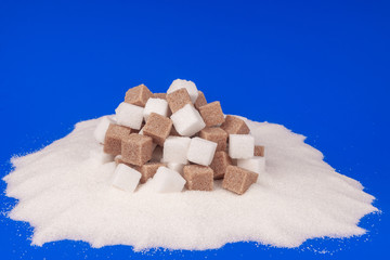 Heap of cane sugar and white sugar on a blue background