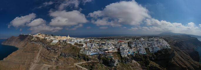 Aerial drone panoramic photo of main village of Santorini island called Fira built uphill with beautiful colours and architecture, Cyclades, Greece