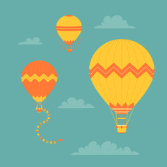 Set of simple yellow and orange hot air balloons on a blue background with clouds. Travel icon collection. Vintage vector illustration.