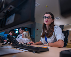 Female security guards working on computers while sitting in the main control room