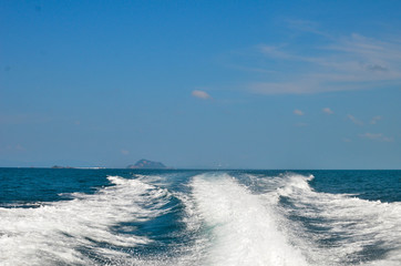 Motor boat created waves blue sea