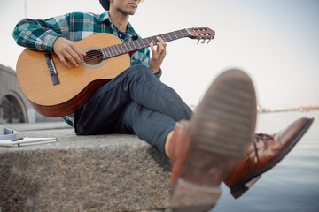 Obraz premium Guitarist holding guitar while looking away outdoors