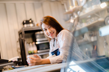 Fototapeta na wymiar Portrait Asian woman Barista preparing coffee at front counter serving coffee cup to customer occupation, part-time,job or owner business working woman happy selling and making drink beverage