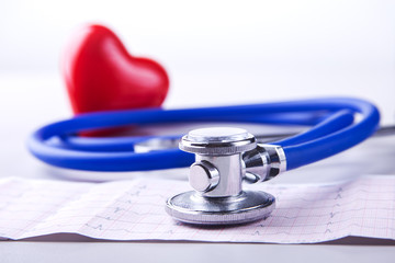 Medical stethoscope and red heart lying on cardiogram chart closeup. Medical help, prophylaxis, disease prevention or insurance concept. Cardiology care.