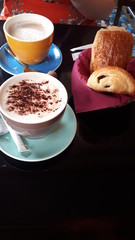 cup of coffee and pain au chocolat on wooden table