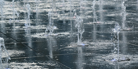 beautiful fountain in the open air, on the street. Drops of water, jets of water frozen in the air in flight against the backdrop.