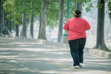 Back view of unidentified man jogging on the roads