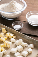 Sheet tray of butter and shortening beside bowls of baking ingredients