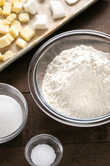 Bowl of flour and baking ingredients beside a sheet pan with butter