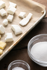 Close up on a baking sheet of shortening and butter, beside a salt dish