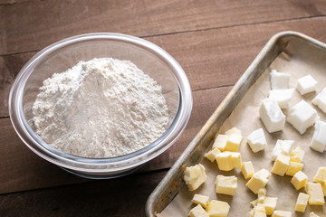 Fototapeta na wymiar Bowl of flour beside a sheet pan with butter and shortening