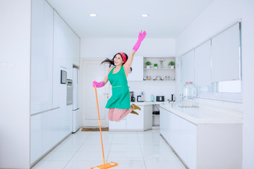 Beautiful woman jumping happily while mopping