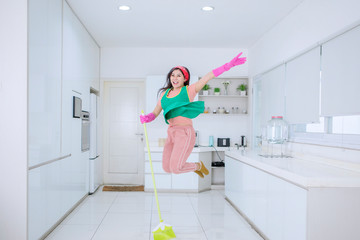 Beautiful woman jumping happily while sweeping